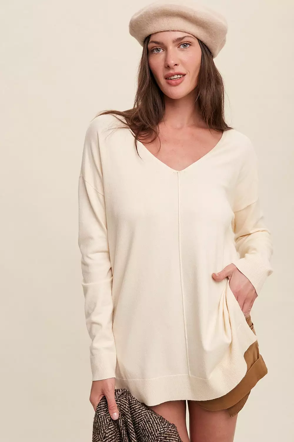 V-neck oversized sweater in cream color.