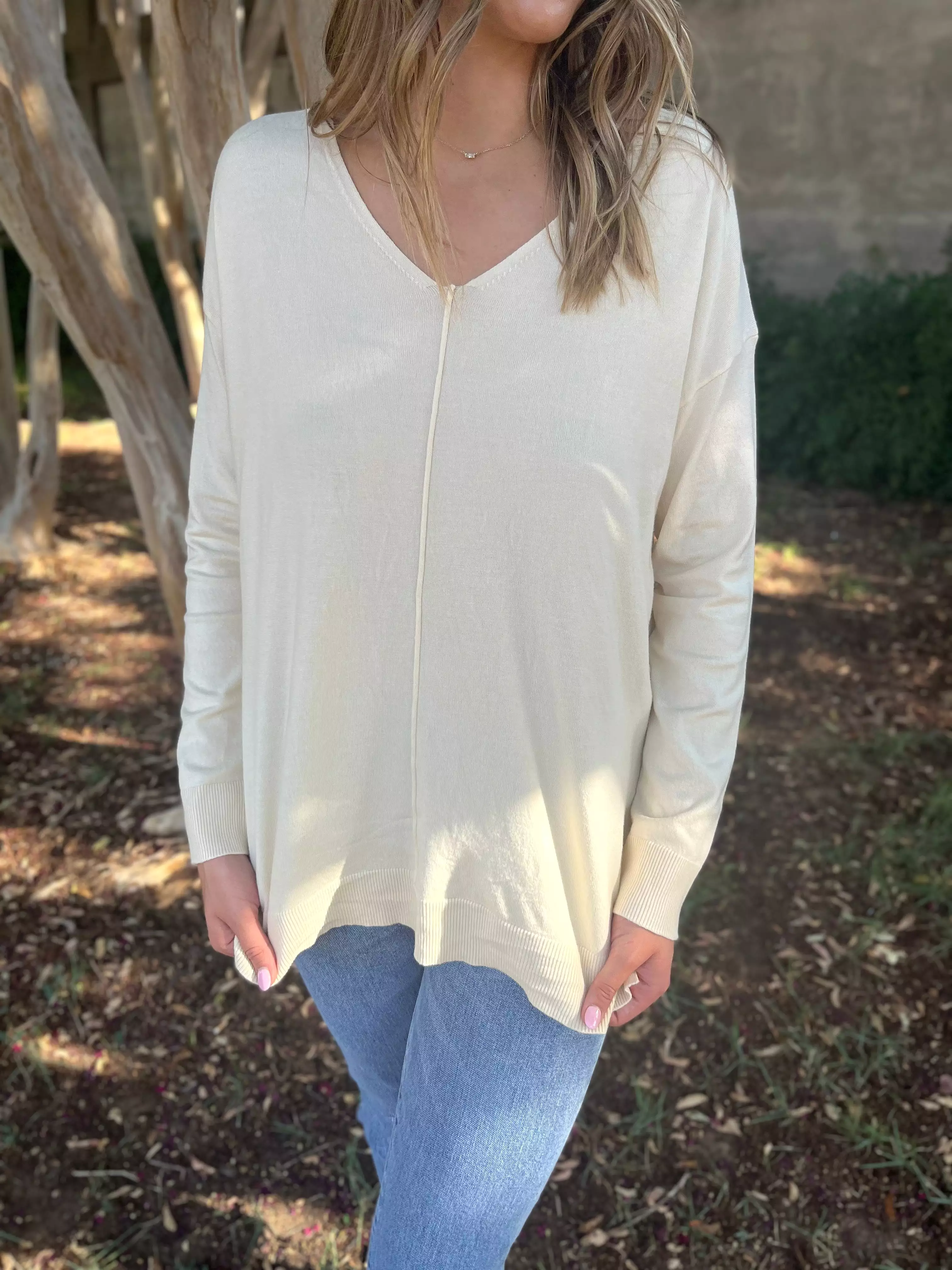 V-neck oversized sweater in cream color.