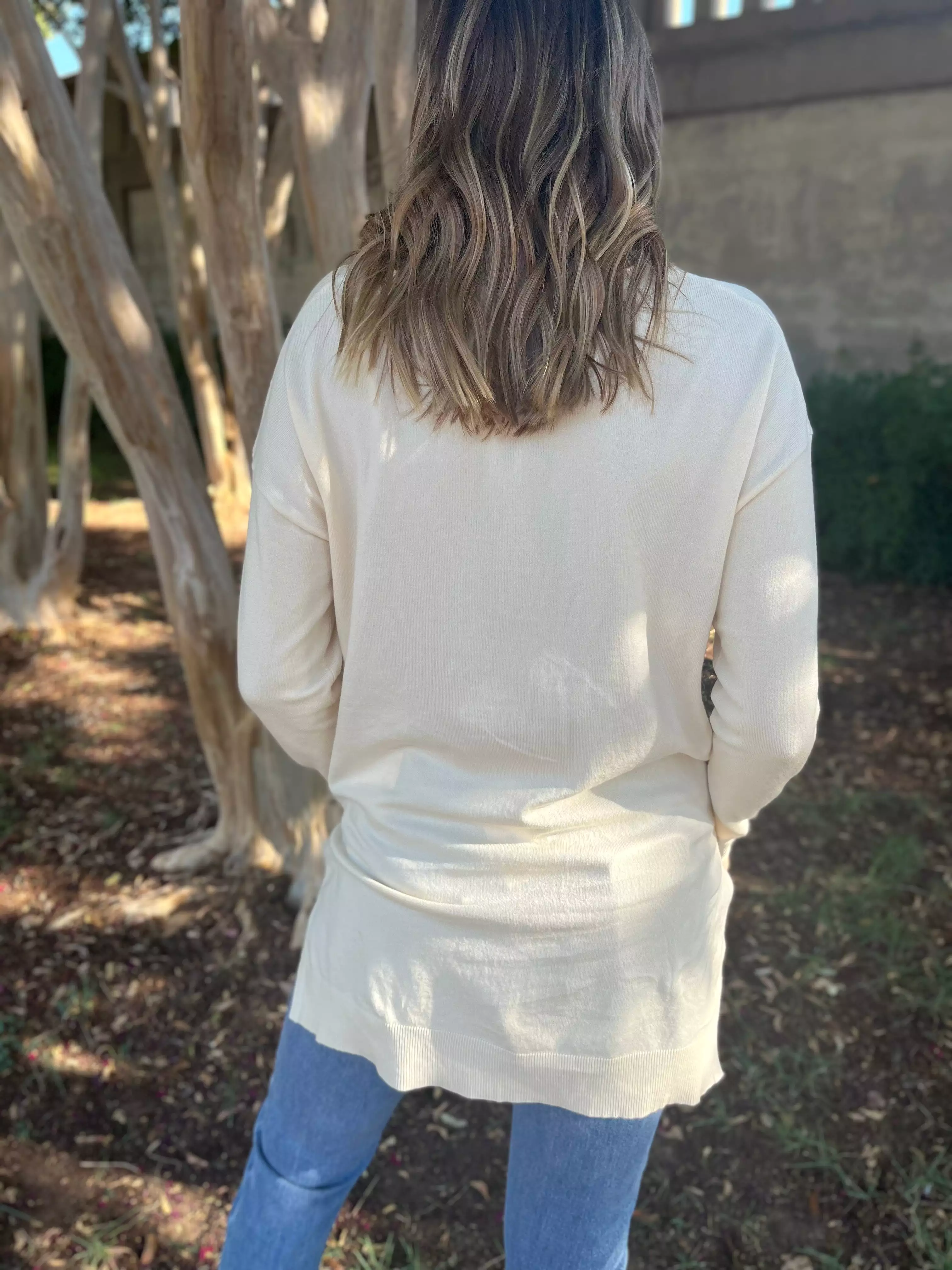 V-neck oversized sweater in cream color.